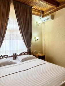 撒马尔罕卡文赛瑞酒店的一间卧室设有一张大床和窗户