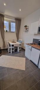 摩泽尔河畔的泽尔Apartment Hallenbach的厨房配有白色的桌子和桌椅