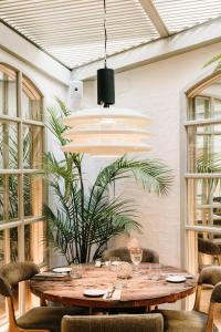 巴塞罗那Hotel Pulitzer Barcelona的一间设有桌子和盆栽的饭厅