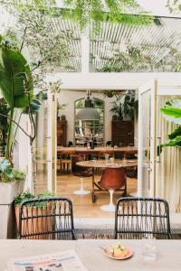 巴塞罗那Hotel Pulitzer Barcelona的一间种有植物的用餐室和一张桌子及椅子