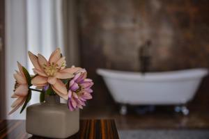 巴统Hotel Monarch的浴室里一个花瓶,桌子上放着鲜花