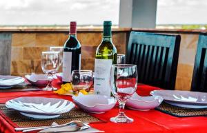 暹粒阳光精品度假酒店及餐厅的一张红桌,上面装有酒瓶和玻璃杯