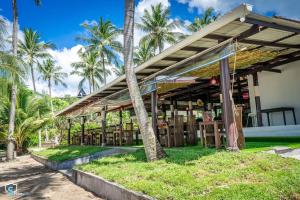 塔林甘海滩Am Samui Resort Taling Ngam的一座楼前种有棕榈树的餐厅