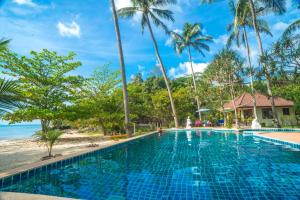 塔林甘海滩Am Samui Resort Taling Ngam的棕榈树海滩旁的游泳池