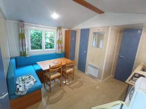 吕奥姆卡彭蒂露营地的小房间设有桌子和蓝色的沙发