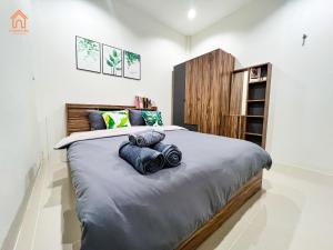 Ban Tha KupBaan lang lek บ้านหลังเล็ก的一间卧室配有一张大床和蓝色枕头