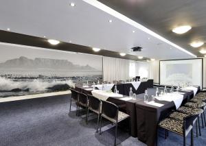 开普敦Peninsula All Suite Hotel by Dream Resorts的一间会议室,配有桌椅和一幅大画