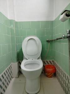 PanaotiCOMMUNITY HOLIDAY INN的绿色瓷砖客房内的卫生间