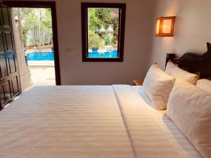 暹粒NeakBong Residence的卧室配有一张大白色床和窗户