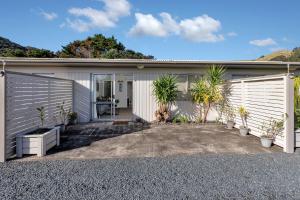 MahinepuaHidden Away - Tauranga Bay Holiday Unit的前面有植物的白色房子