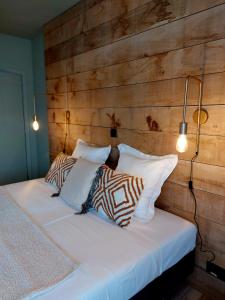 马尔梅迪MyDeer - Deluxe rooms & shared kitchen的一间卧室设有木墙和一张带枕头的床。