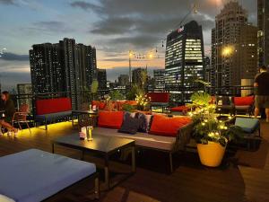 马尼拉The Residences at BCCT的一个带沙发和桌子的屋顶露台,并享有城市美景。
