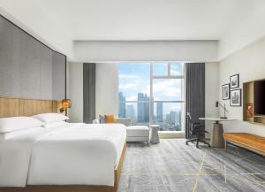 广州Sheraton Guangzhou Hotel的酒店客房设有一张床和一个大窗户