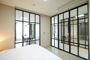 平昌Pyeongchang The White Hotel的一间卧室设有大型玻璃窗和一张床