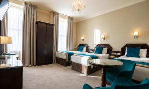 都柏林哈考特酒店的酒店客房设有三张床和吊灯。