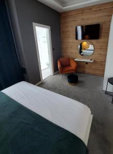 萨格勒布A8 b&b的一间卧室配有一张床、一把椅子和电视