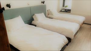 TreorkyCardiff Arms Bistro & Hotel的配有白色床单和枕头的三张床