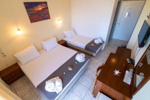 米提卡斯Iraklis Hotel的小房间设有一张床和一张桌子