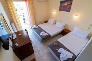 米提卡斯Iraklis Hotel的一间设有两张床铺和毛巾的房间