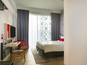 马斯喀特IntercityHotel Muscat的酒店客房配有一张床铺、一张桌子和一张书桌。