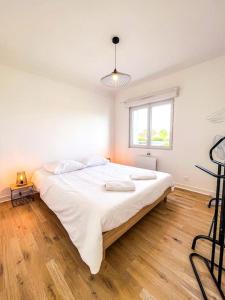 DéolsLe Convivial • Stationnement Facile • Paisible的铺有木地板的客房内一张大白色的床