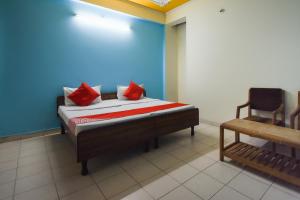 RāiwālaOYO Wings Guest House的一间卧室配有一张带红色枕头的床