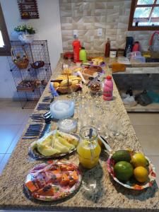 帕蒂杜阿尔费里斯Pousada e Pesque e Pague Vista Alegre的厨房柜台,上面有食物和水果盘