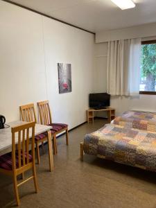 科特卡Guesthouse - Kuin Kotonaan的卧室配有一张床和一张桌子及椅子