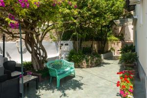 伊斯基亚Villa dei Sogni - Aparthotel Ischia Ponte的鲜花庭院里蓝色长椅