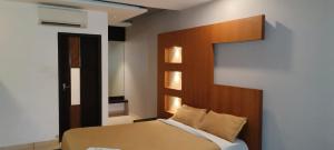 KondottiHOTEL AL AMANA TOWER的一间卧室配有一张带木制床头板的床