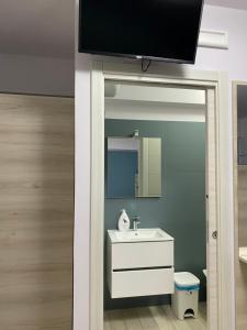法尔科内La casa dell’Aurora的一间带水槽的浴室和墙上的电视
