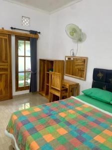 罗威那Penginapan Sedap Malam的一间卧室配有一张床、一张桌子和一个窗户。