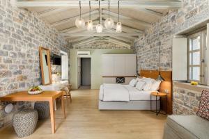 利梅尼Trapela Limeni Luxury Suites的一间卧室设有一张床和砖墙