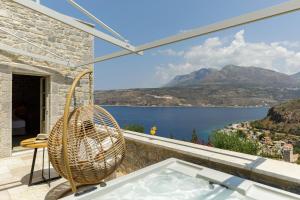 利梅尼Trapela Limeni Luxury Suites的客房享有水景,设有浴缸。