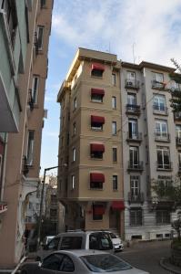 伊斯坦布尔Hotel Taksim Home的一座高大的建筑,在城市里设有红色的阳台