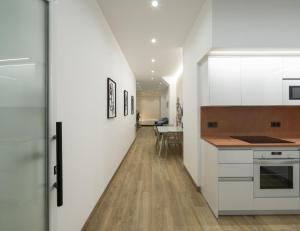 格拉纳达Apartamentos Mª Luisa de Dios Nº7的厨房配有白色橱柜和长长的走廊