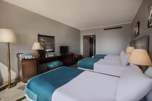 卢克索Pyramisa Hotel Luxor的酒店客房配有两张床和一张书桌