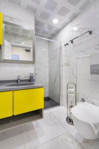 阿拉尼亚拜拉姆公寓酒店 的浴室配有黄色水槽和淋浴。