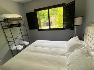 蒙达卡Mundaka Beachfront House的卧室配有白色的床和窗户。