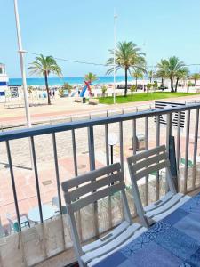 甘迪亚海滩Apartamento TalaMar Gandia Playa的两把白色椅子坐在俯瞰着海滩的阳台上