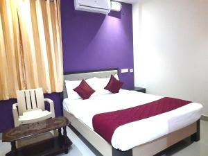 坦贾武尔Hotel Abedrooms- Budget stay Thanjavur的一间卧室配有一张紫色墙壁的床