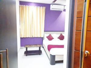 坦贾武尔Hotel Abedrooms- Budget stay Thanjavur的小房间,里面设有床和凳子