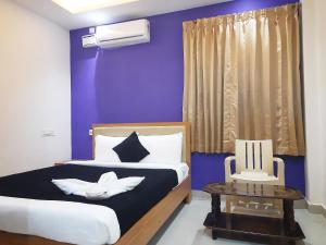 坦贾武尔Hotel Abedrooms- Budget stay Thanjavur的蓝色卧室,配有床和桌子