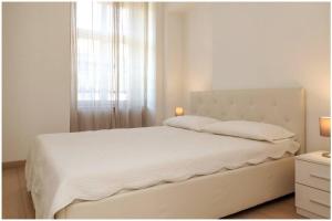 都灵Casa San Carlo nel cuore di Torino的白色卧室设有一张大床和窗户