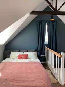 KelmėLovely Tiny House的一间卧室设有一张床和蓝色的墙壁