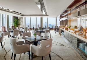 广州广州广交会威斯汀酒店的餐厅设有桌椅和窗户。