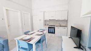 特罗佩阿Il Narciso Residence的一间带桌椅的厨房和一台电视