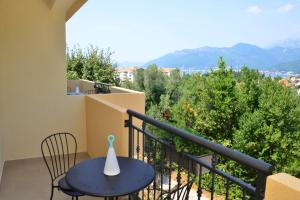 蒂瓦特Bradasevic Apart Resort Tivat的阳台配有蓝色的桌椅和山脉