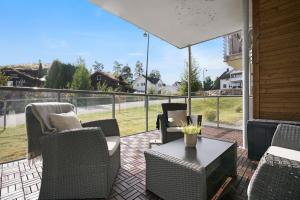 RåholtModerne leilighet - nært flyplass - lader for elbil的一个带桌椅的庭院和大窗户