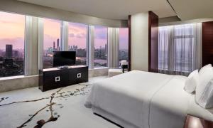 广州广州广交会威斯汀酒店的一间卧室设有一张床、一台电视和大窗户